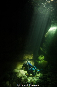 A diver under sun rays through the crystal clear waters o... by Brent Barnes 